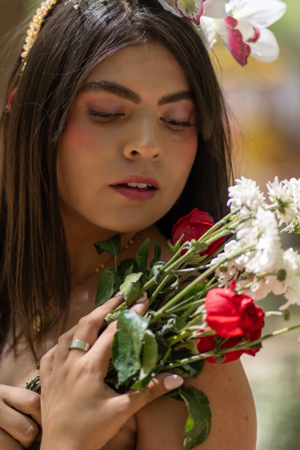 A striking portrait of a woman with artistic makeup holding a vibrant bouquet of flowers. Mobile 4K