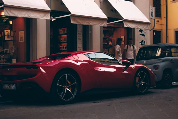 A striking red supercar parked on a quaint street in Floransa, Tuscany, Italy. Voitures 4K