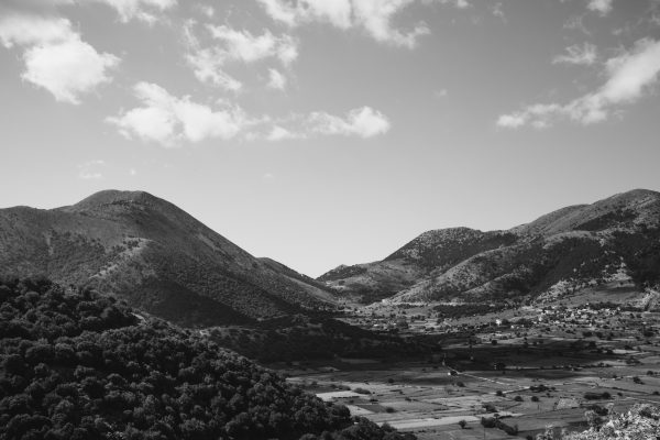 A stunning black and white aerial view capturing scenic countryside hills and rural landscape. Nature 4K