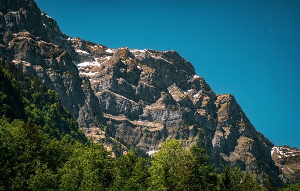 A stunning scene of the Glarus Alps in Switzerland showcasing rocky peaks and lush greenery. Nature 4K