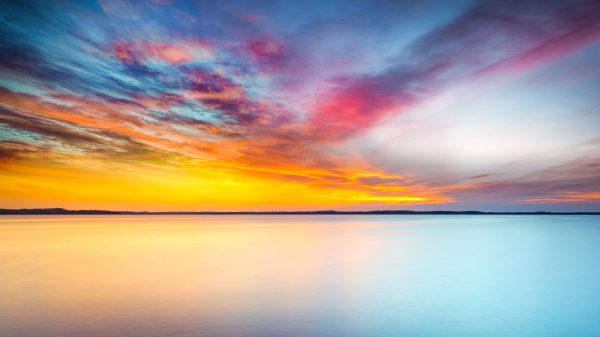 A stunning sunset scene with vibrant skies reflecting on serene ocean waters, perfect for nature enthusiasts. Abstrait 4K