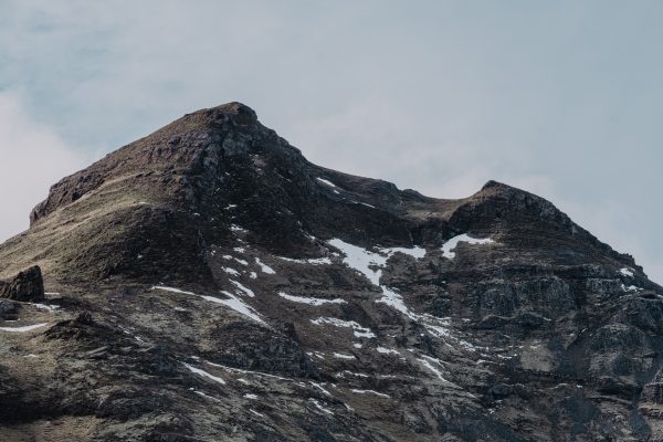 A stunning view of a rugged snow-capped mountain under a clear sky. Nature 4K