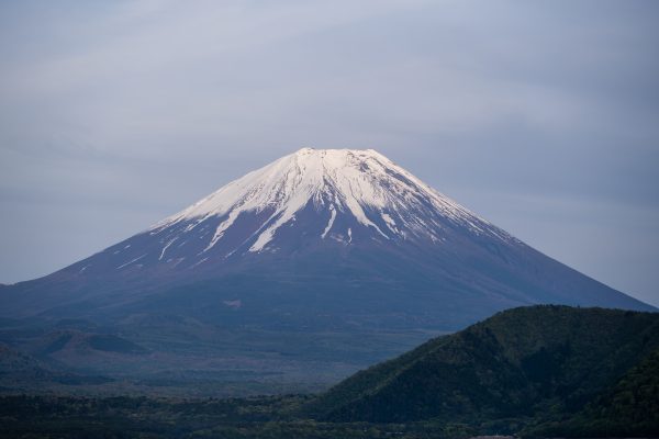 A stunning view of Mount Fuji with snow capped peak against a serene blue sky. Anime 4K