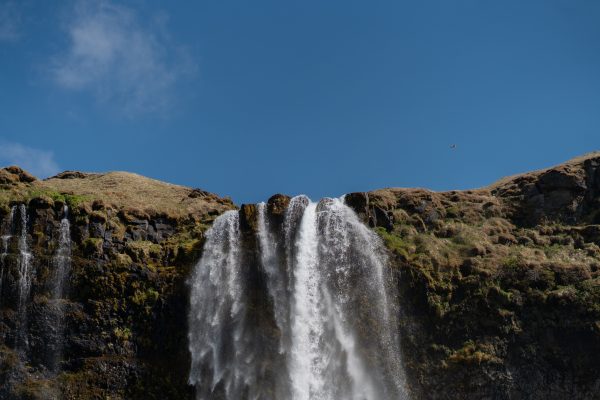 A stunning view of Seljalandsfoss waterfall against a clear blue sky in Iceland. Nature 4K