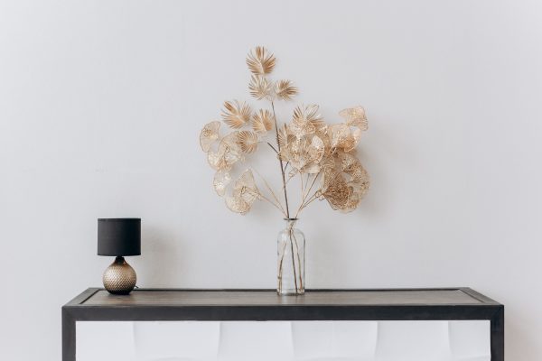A stylish minimalist interior with a floral arrangement and a sleek lamp on a wooden table. Minimaliste 4K