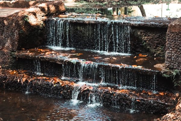 A tranquil cascade with flowing water over rocky steps in a natural setting in Goiás, Brazil. Nature 4K
