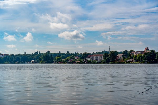 A tranquil view of Lychen Lake with the town skyline under a bright summer sky. Nature 4K