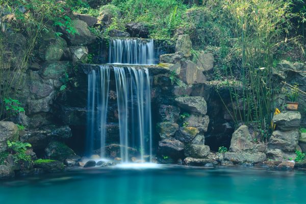 A tranquil waterfall cascading over rocks in a lush forest near Hangzhou, China. Nature 4K