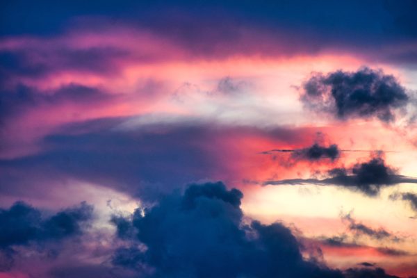 A vibrant and dramatic sunset sky with colorful clouds displaying a beautiful natural gradient. Dark 4K