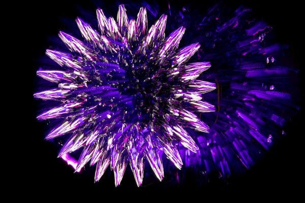 A vibrant and intricate glowing purple fractal resembling a crystal structure set against a dark background. Abstrait 4K