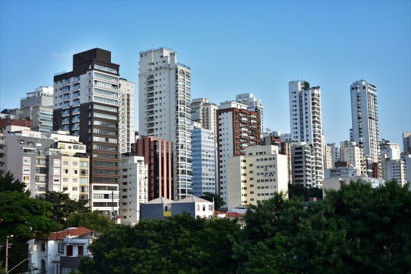 A vibrant cityscape showcasing modern high-rise buildings against a clear blue sky. Architecture 4K