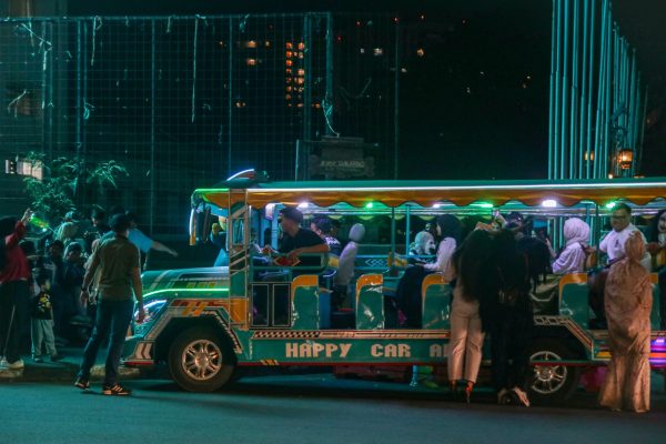 A vibrant night scene with a colorful tour bus and passengers in an urban environment. Voitures 4K