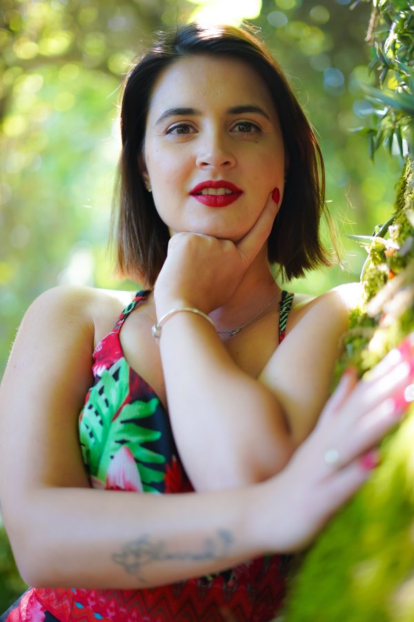 A vibrant portrait of a woman posing thoughtfully in the lush greenery of Sintra, Portugal. Mobile 4K