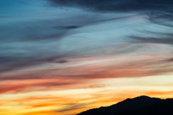 A vibrant sunset with colorful clouds over silhouetted hills, perfect for nature enthusiasts. Nature 4K