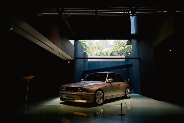 A vintage luxury car in a contemporary indoor showroom, captured during the day. Voitures 4K