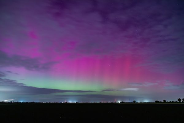 A vivid display of the aurora borealis in the night sky with purple and green hues. Espace 4K
