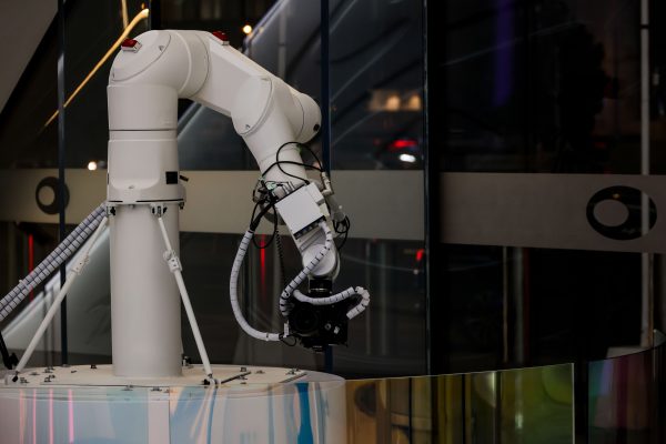 A white robotic arm operating indoors with a modern design and advanced technology. Geek 4K