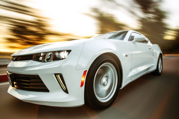 A white sportscar in motion showcasing speed and style on an open road. Voitures 4K