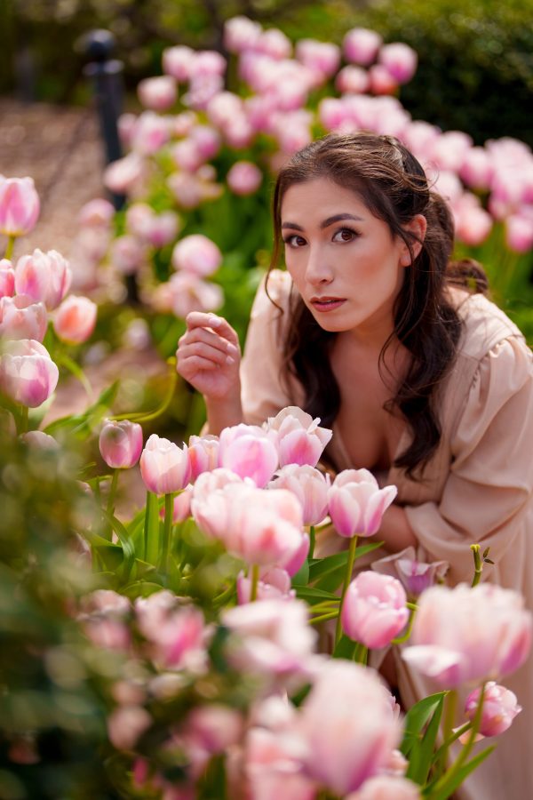 A woman poses amid blooming tulips in a San Francisco garden, capturing spring's vibrant charm. Mobile 4K