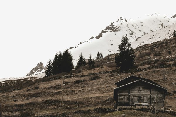 A wooden cabin in a serene snowy mountain landscape captures rustic beauty. Nature 4K