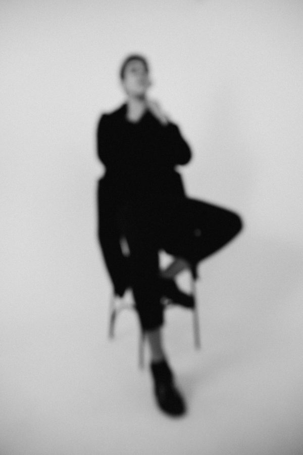 Abstract black and white portrait of person sitting, blurred for artistic effect. Mobile 4K