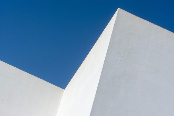 Abstract view of a white geometric architectural structure against a vibrant blue sky. Minimaliste 4K
