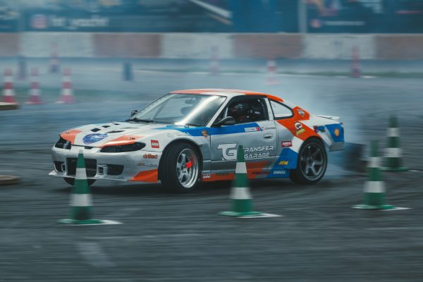 Action-packed scene of a customized car drifting around cones on a race track. Voitures 4K