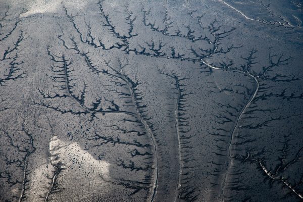 Aerial photograph showcasing intricate river patterns on a barren landscape, resembling natural fractal patterns. Abstrait 4K
