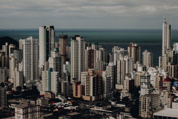 Aerial view of a modern urban skyline with tall skyscrapers overlooking the ocean. Architecture 4K