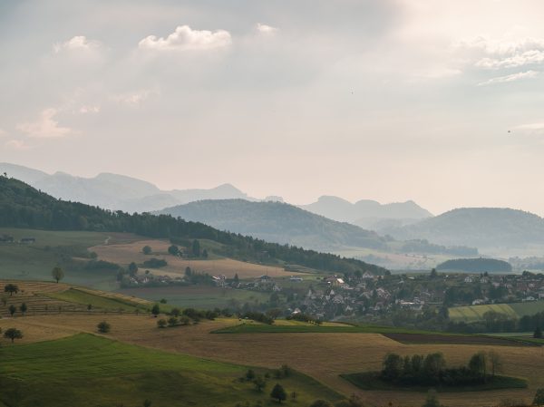 Aerial view of a peaceful countryside with rolling hills and fog in the distance, perfect for a tranquil escape. Nature 4K