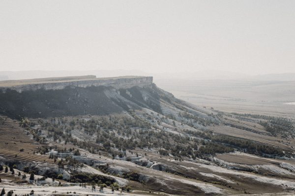 Aerial view of a stunning plateau in a serene, expansive valley with unique geological formations under a bright sky. Nature 4K
