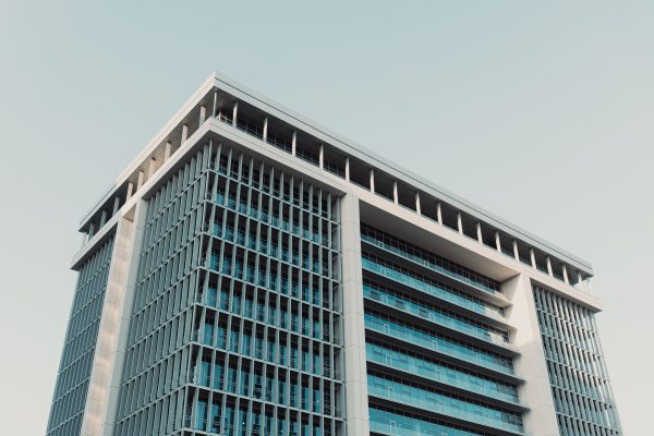 Architectural shot of a modern high-rise office building with a prominent glass facade, shot at daytime. Architecture 4K