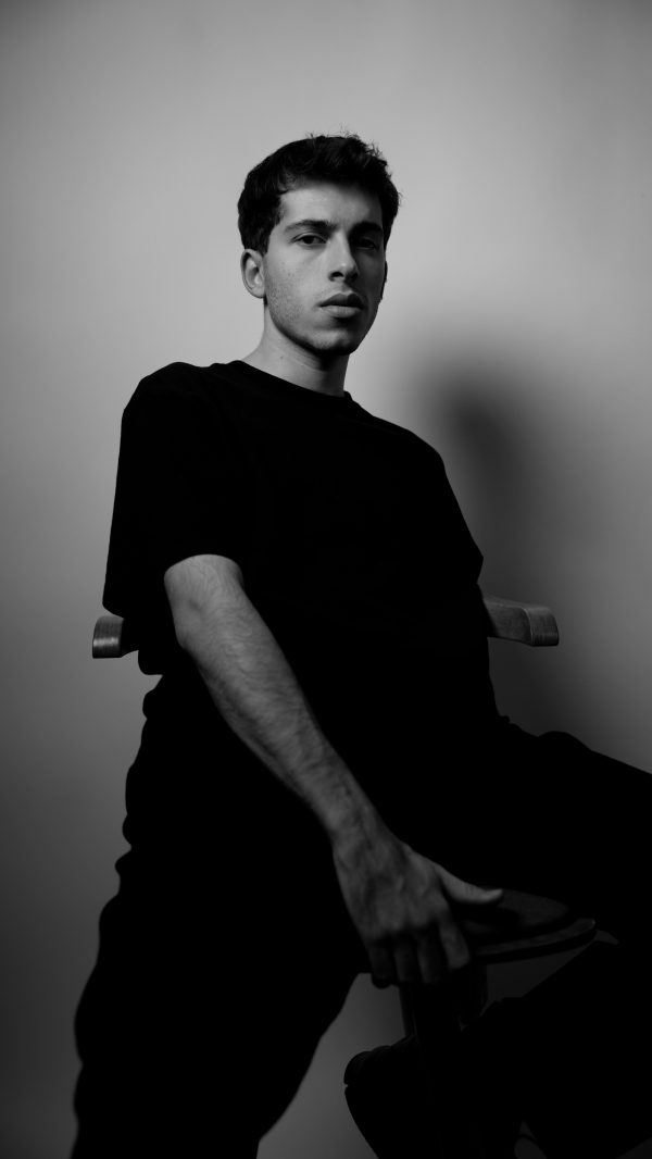 Artistic black and white portrait of a young man, highlighting moody and dramatic tones. Mobile 4K