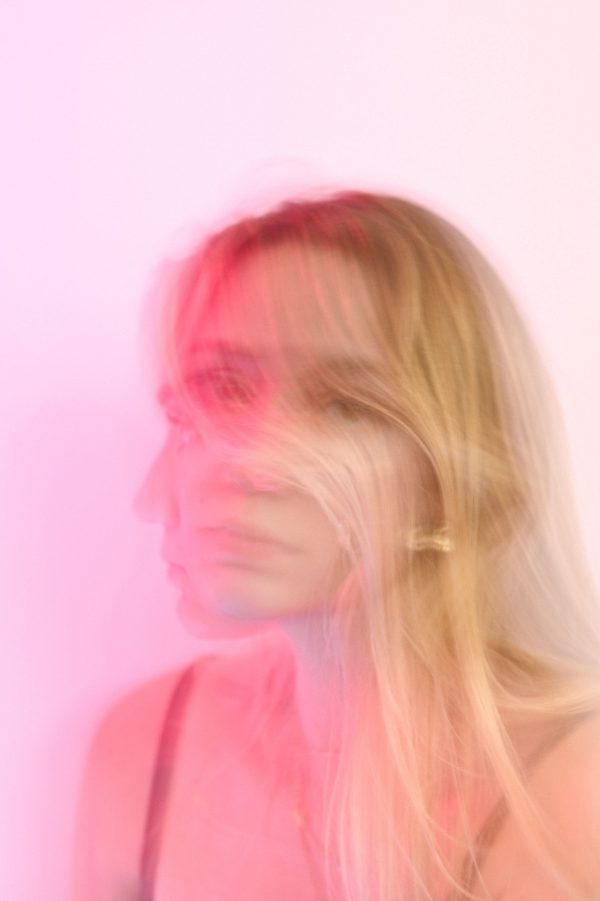 Artistic blurred portrait of a woman with pink hues creating a dreamy effect. Mobile 4K