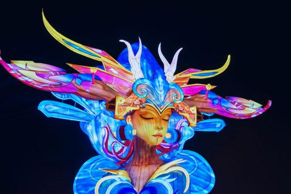 Artistic illuminated lantern displayed at a night festival, showcasing vibrant colors and intricate design under a dark sky. IA Générative 4K