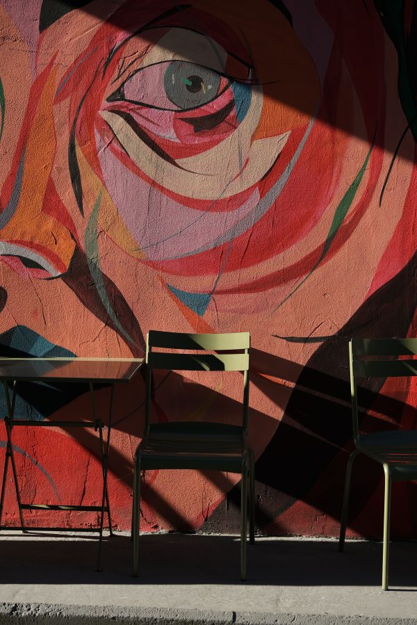 Artistic mural with chairs casting shadows in Istanbul's streets. Mobile 4K