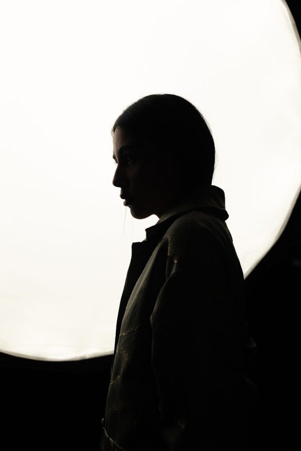 Artistic silhouette of a woman in profile with bold lighting, creating a dramatic mood. Mobile 4K