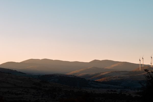 Beautiful landscape at sunset with wind turbines silhouetted against rolling hills, showcasing renewable energy in nature. Nature 4K