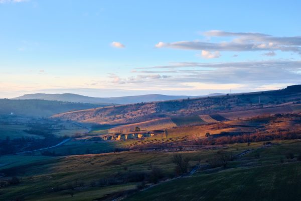 Beautiful landscape of rolling hills with soft sunset lighting and scattered clouds. Nature 4K