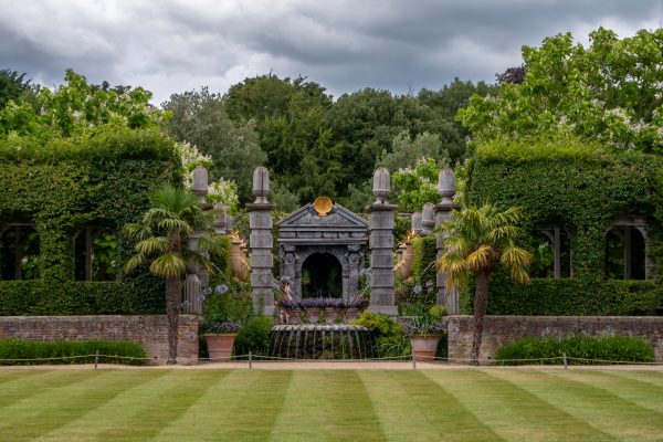Beautiful outdoor garden with a stone fountain surrounded by greenery and trees. Nature 4K