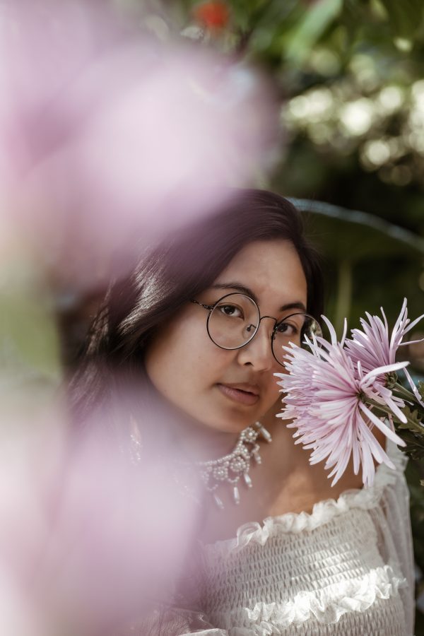 Beautiful portrait of a woman wearing glasses surrounded by vibrant pink flowers in Winter Park, Florida. Mobile 4K
