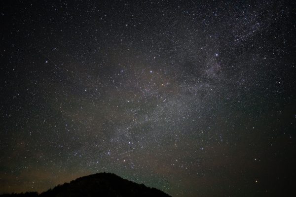 Beautiful starry night sky with a clear view of the Milky Way and a silhouetted hill in the foreground. Espace 4K