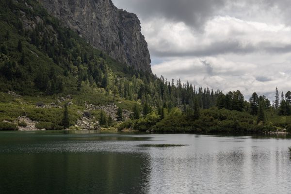 Beautiful Tatra mountain landscape with a serene lake and lush forest under cloudy skies. Nature 4K