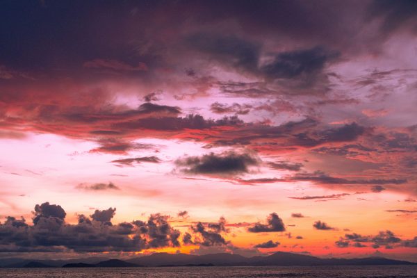 Beautiful view of a dramatic sunset over the sea with colorful clouds. Nature 4K