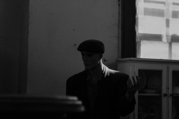 Black and white photo of a mannequin in dramatic light and shadow. Dark 4K