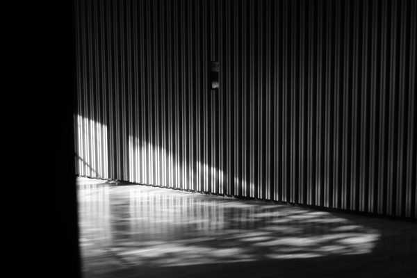 Black and white photo of a sunlit interior in Zaragoza, Spain, highlighting textured walls. Dark 4K