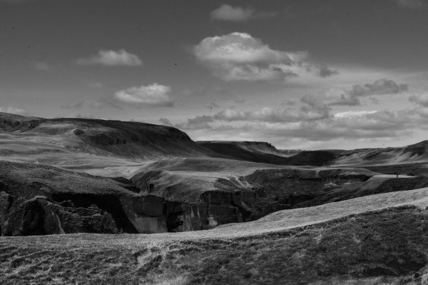 Black and white photo of Fjaðrárgljúfur Canyon in Iceland with dramatic clouds. Nature 4K