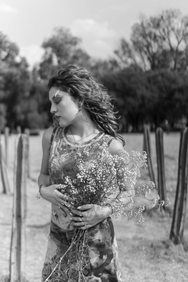 Black and white portrait of a Latina woman with artistic flower makeup in a Mexican field. Mobile 4K