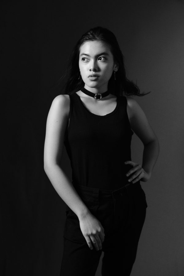 Black and white portrait of a woman posing confidently in a tank top, showcasing elegance. Mobile 4K