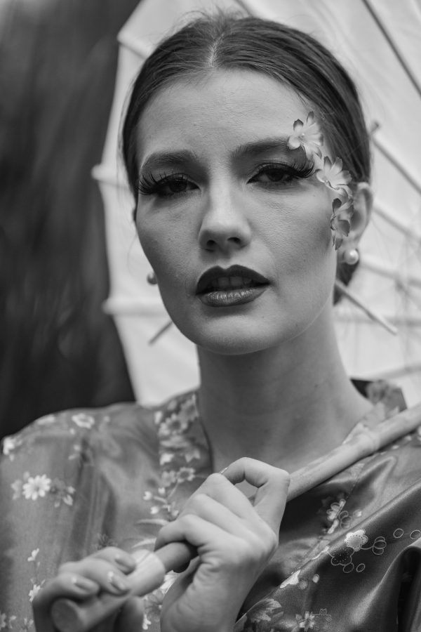 Black and white portrait of an elegant woman with an umbrella, in traditional attire, showcasing artistic makeup. Mobile 4K